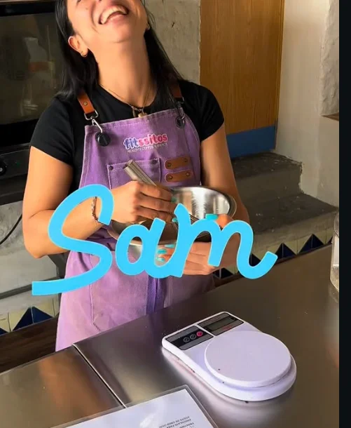 Sam, del equipo Fitssitos, riendo mientras hornea con su delantal morado
